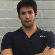 Young man with short dark hair and five o'clock shadow